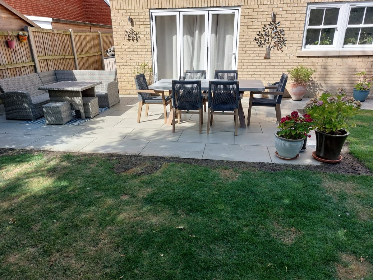 Finished garden patio with outdoor dining furniture and planting pots