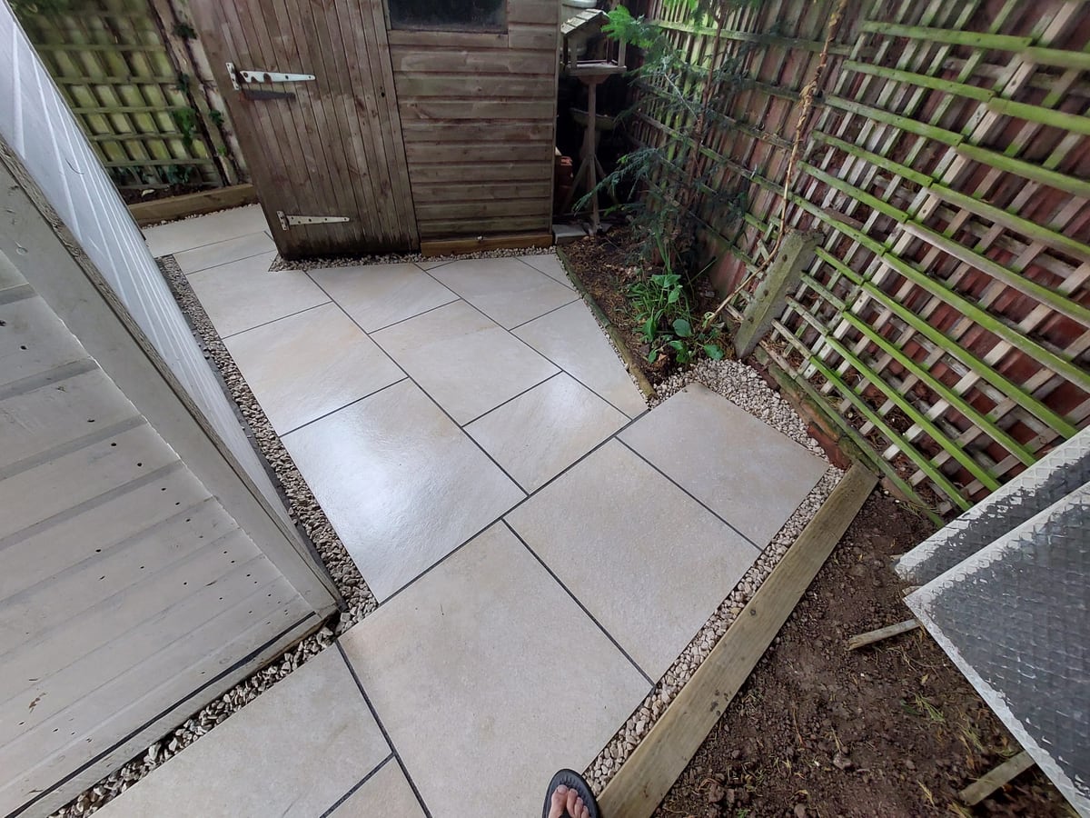 Large finished patio area with lawn and raised timber edging